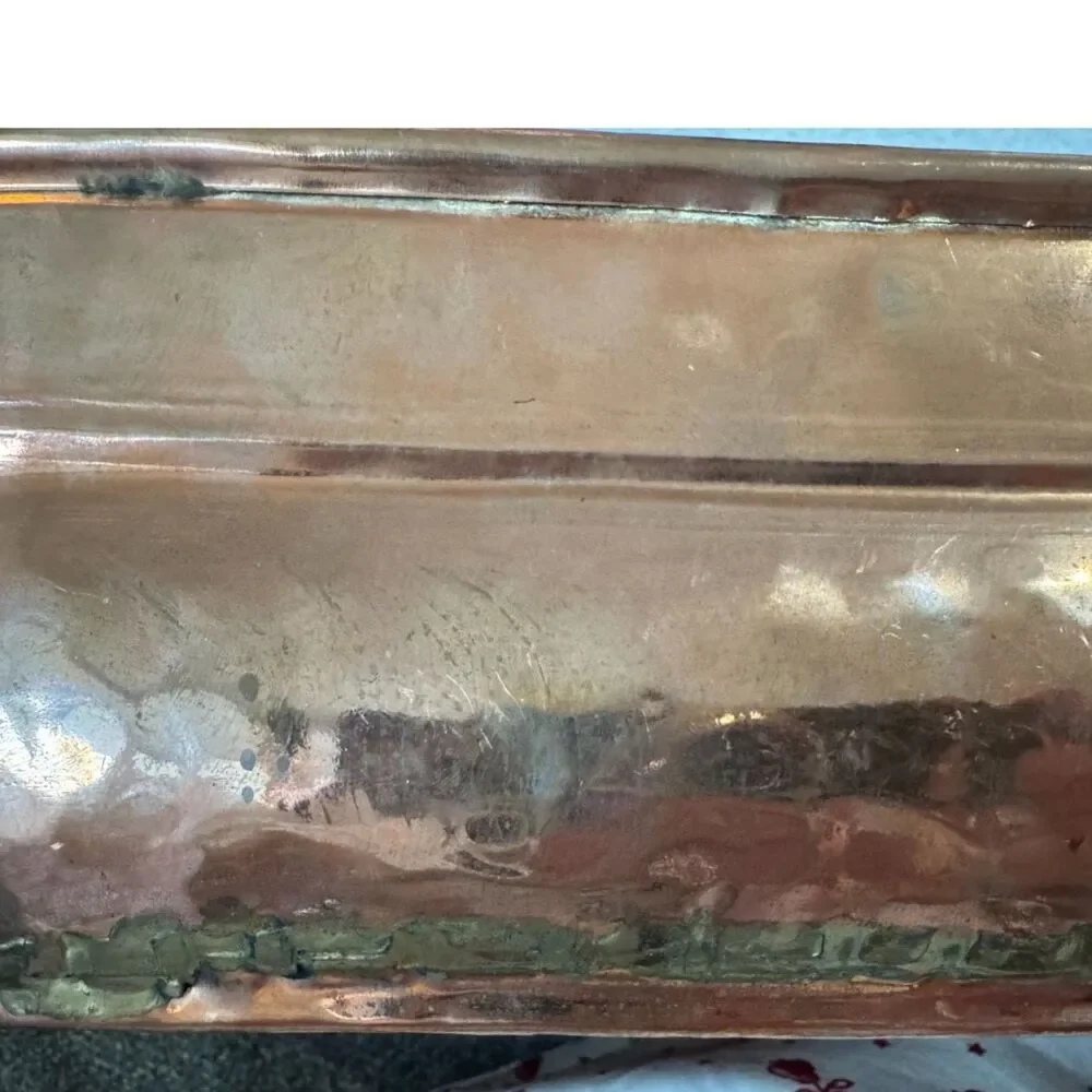 Antique hand-worked copper vessel visible dovetailed/soldered seam, hammered